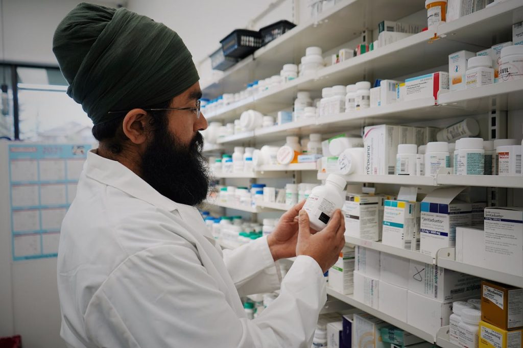 Mastering the First Impression: Your intriguing post title goes here Pharmacist with turban organizing shelves in a pharmacy, focused on healthcare.